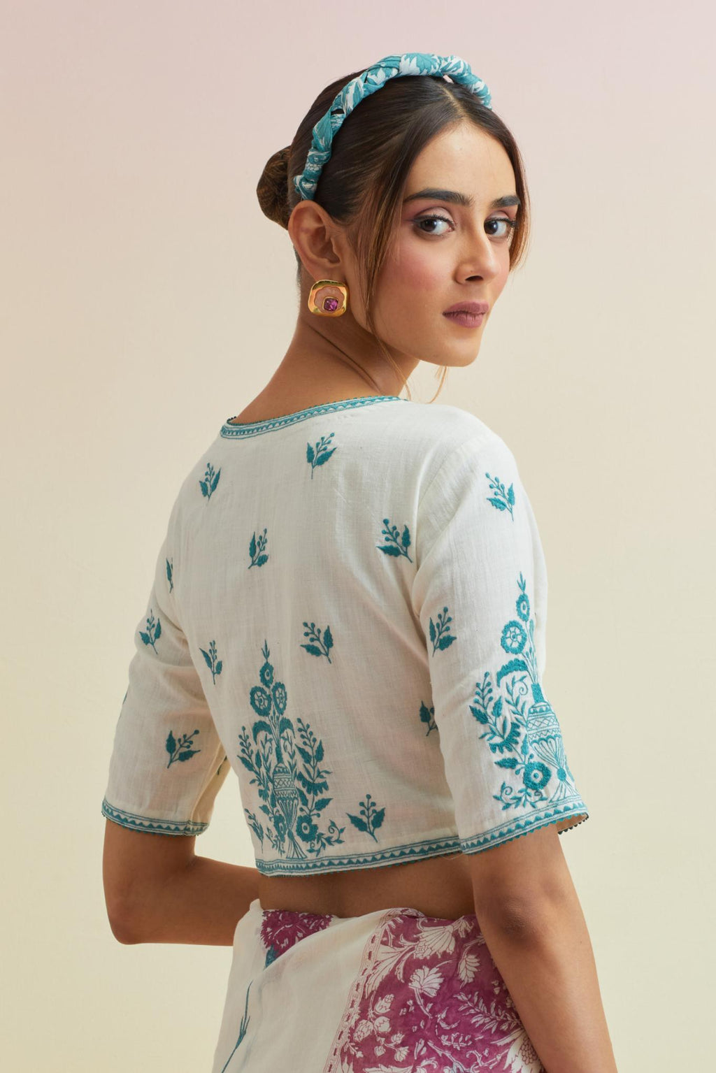 Orchid pink hand block cotton chanderi saree, highlighted with all-over carnation flower print, paired with off-white cotton blouse with all-over tropical teal thread embroidery.