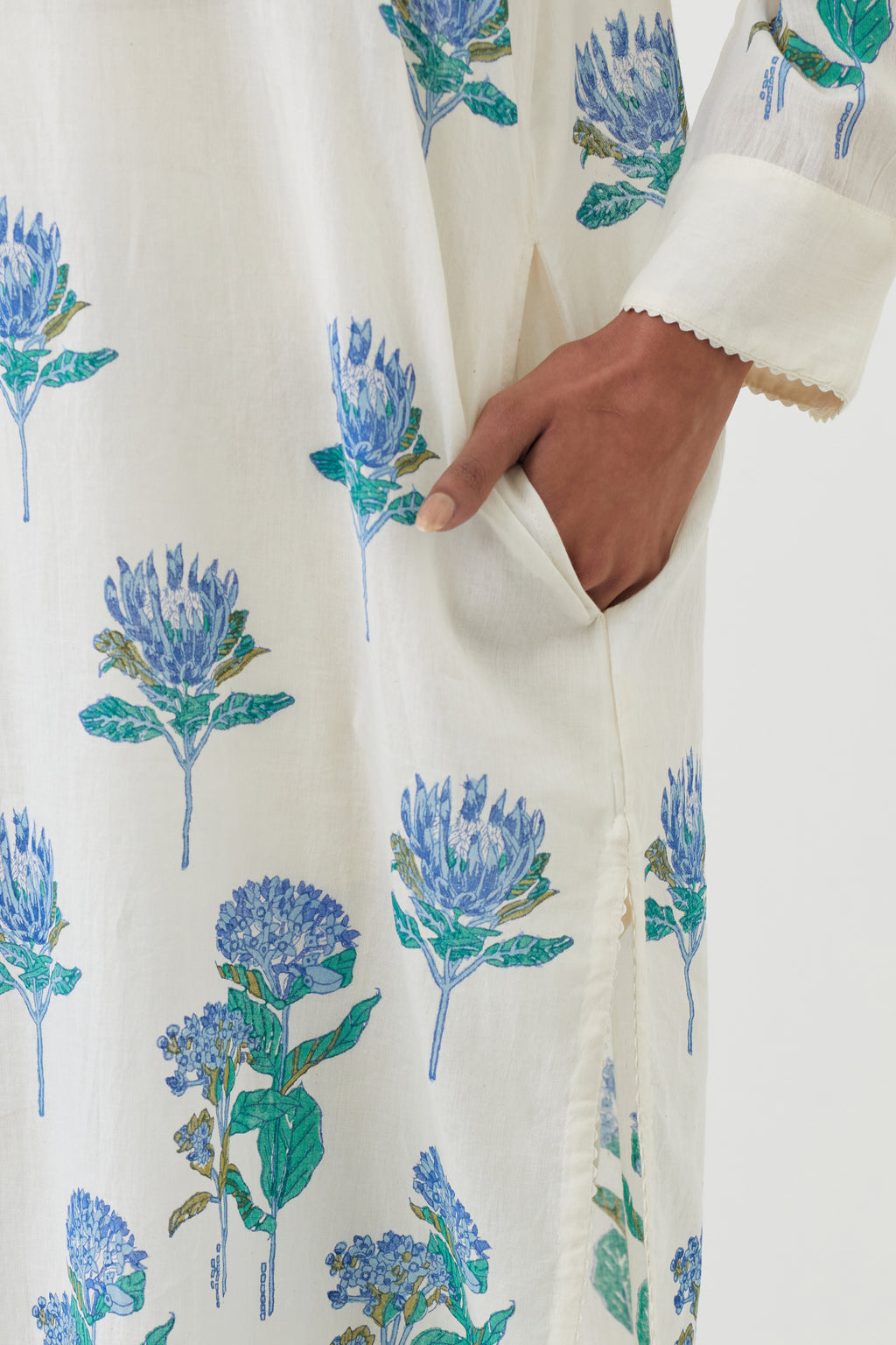 Off white cotton straight short kurta with all-over blue colored flower, paired with off white Cotton straight ankle length pants with hand block print border detail at hem.