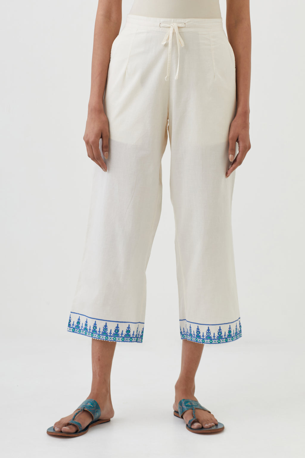 Off white cotton ankle length pants with hand block print detailing at bottom hem.