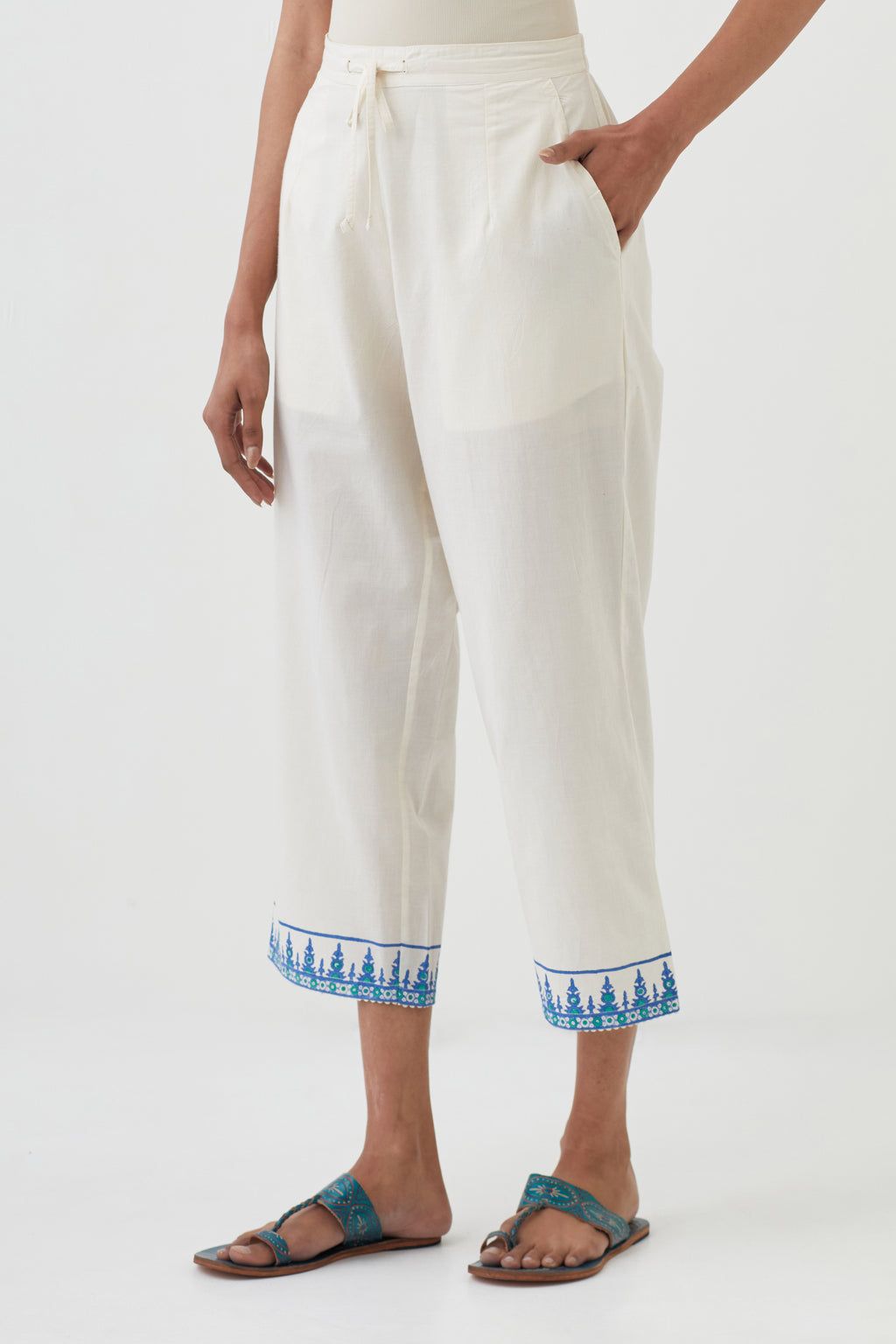 Off white cotton ankle length pants with hand block print detailing at bottom hem.