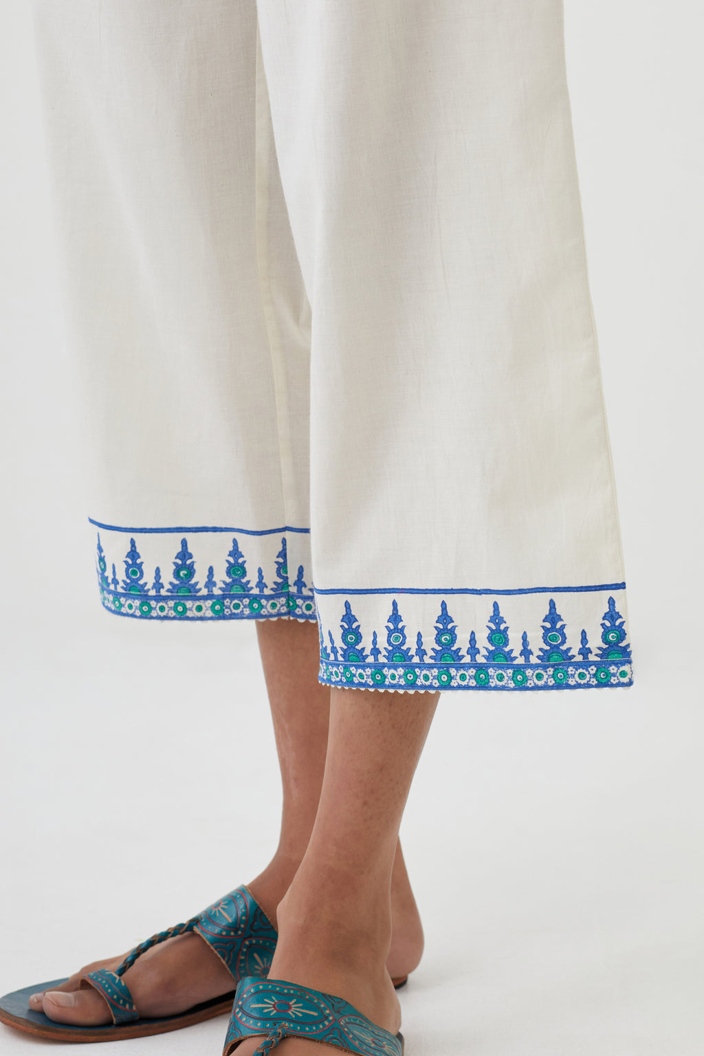 Off white cotton ankle length pants with hand block print detailing at bottom hem.