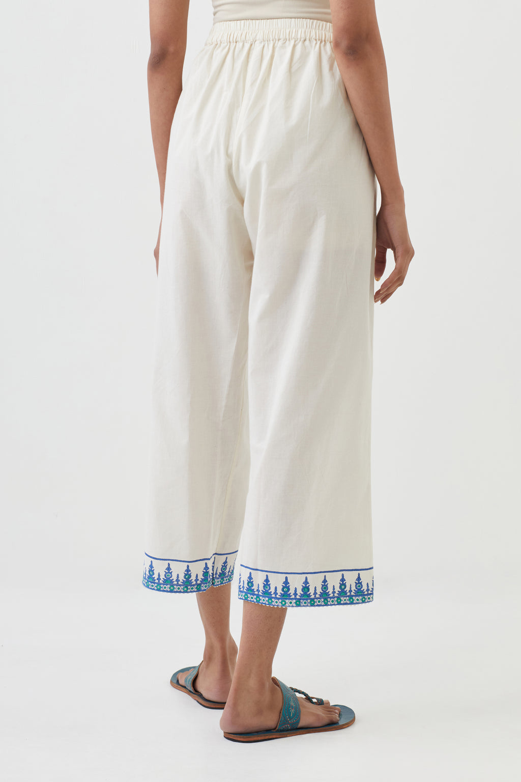 Off white cotton ankle length pants with hand block print detailing at bottom hem.