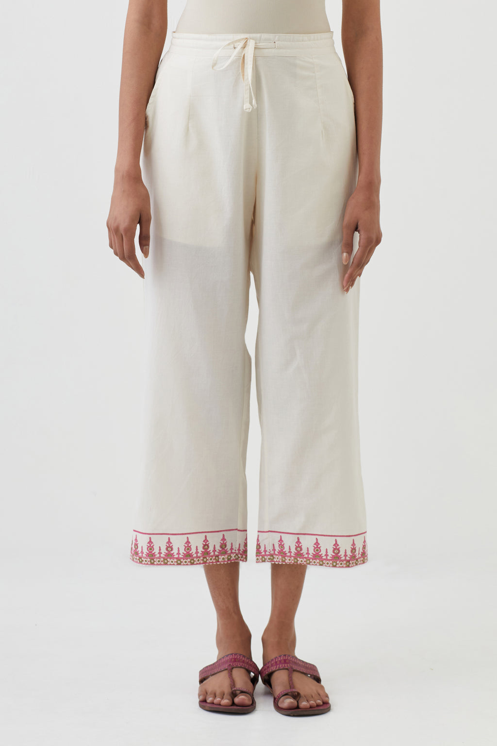 Off white cotton ankle length pants with hand block print detailing at bottom hem.