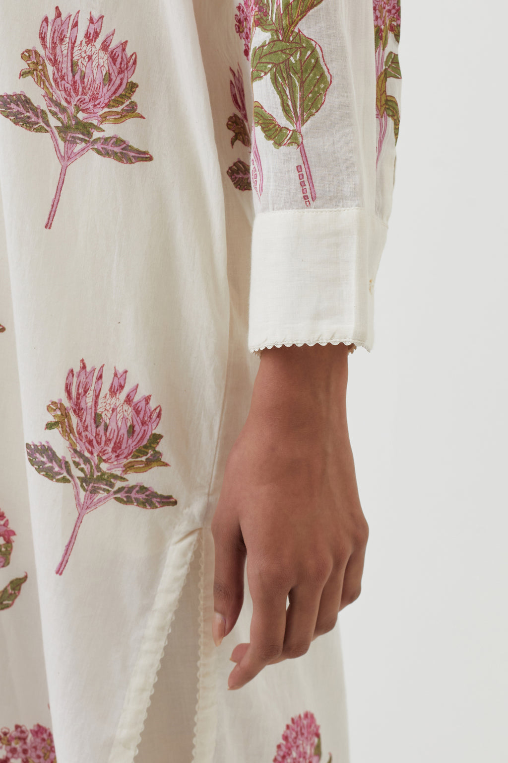 Off white cotton straight short kurta with all-over pink colored flower, paired with off white Cotton straight ankle length pants with hand block print border detail at hem.