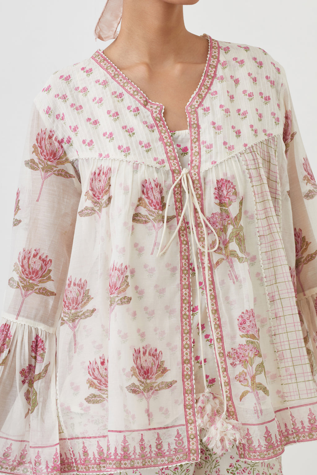 Pink hand block printed short top with hand block printed cotton slip inside, paired with off white hand block printed Cotton ankle length straight pants with all-over pink colored flower.