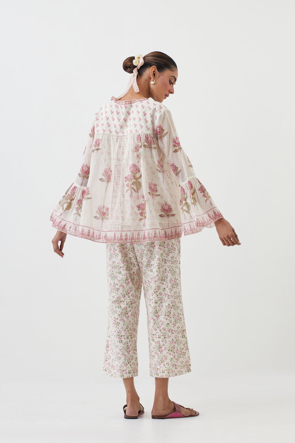 Pink hand block printed short top with hand block printed cotton slip inside, paired with off white hand block printed Cotton ankle length straight pants with all-over pink colored flower.