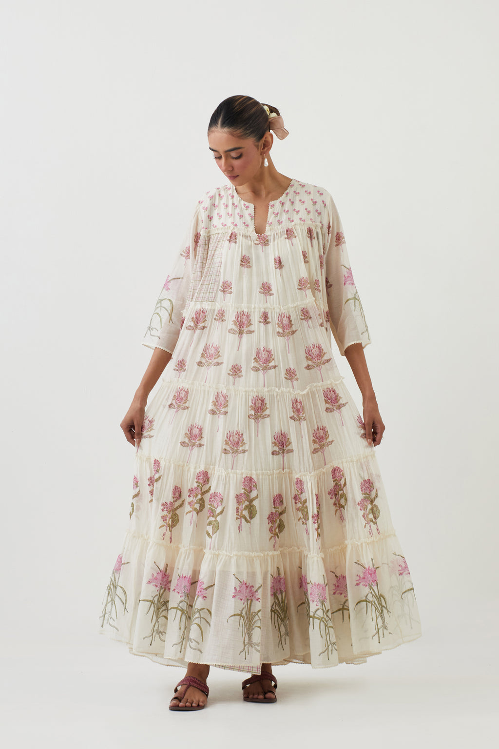 Off white hand block printed multi-tiered kurta set with quilted yoke and all-over pink colored flower.