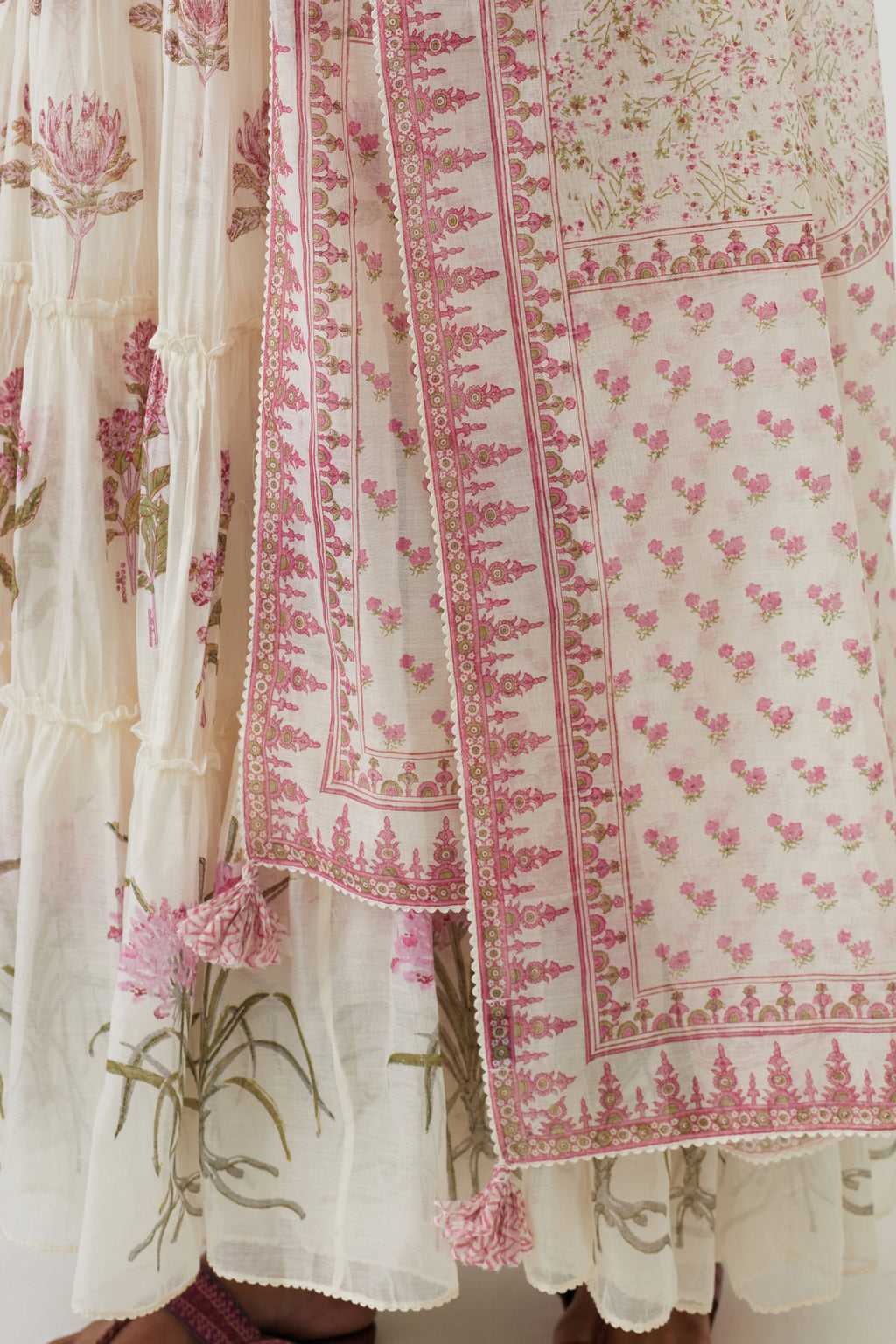Off white hand block printed multi-tiered kurta set with quilted yoke and all-over pink colored flower.