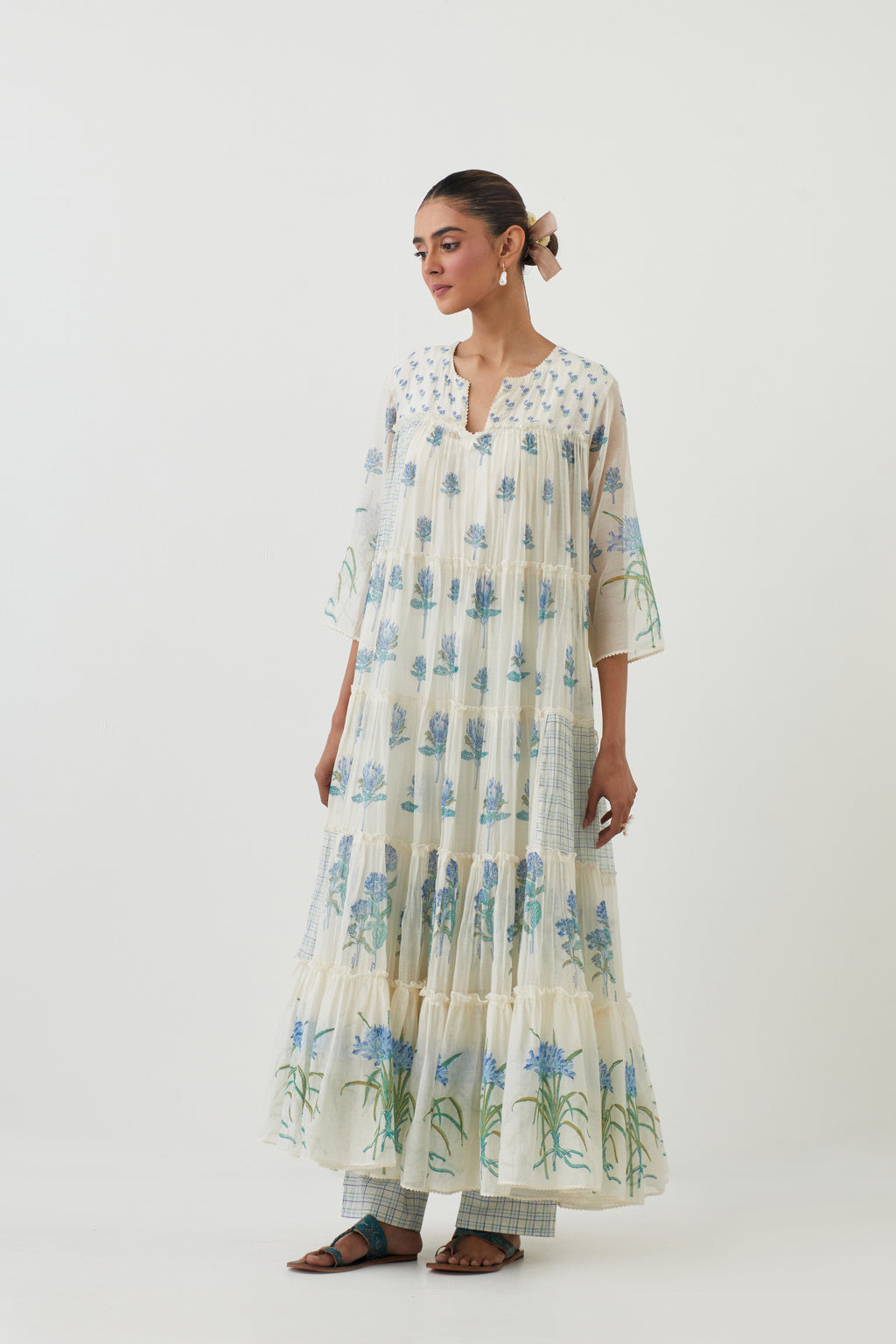 Off white hand block printed multi-tiered kurta set with quilted yoke and all-over blue colored flower.