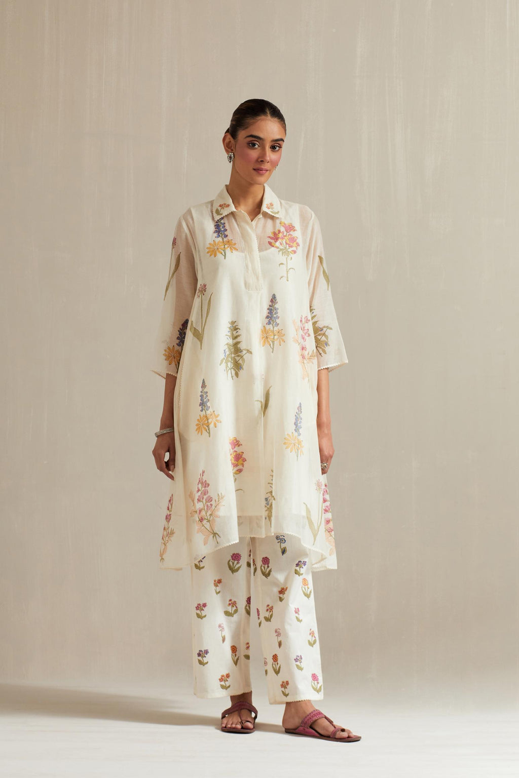 Off white hand block printed A-line short kurta set with all-over multi colored flower.