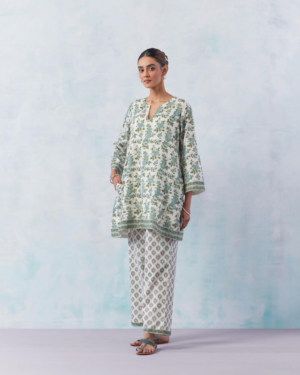 Teal green hand block printed easy fit short kurta with faggoting detailing all over the kurta, paired with off white cotton straight pants with all-over small booti hand block print.