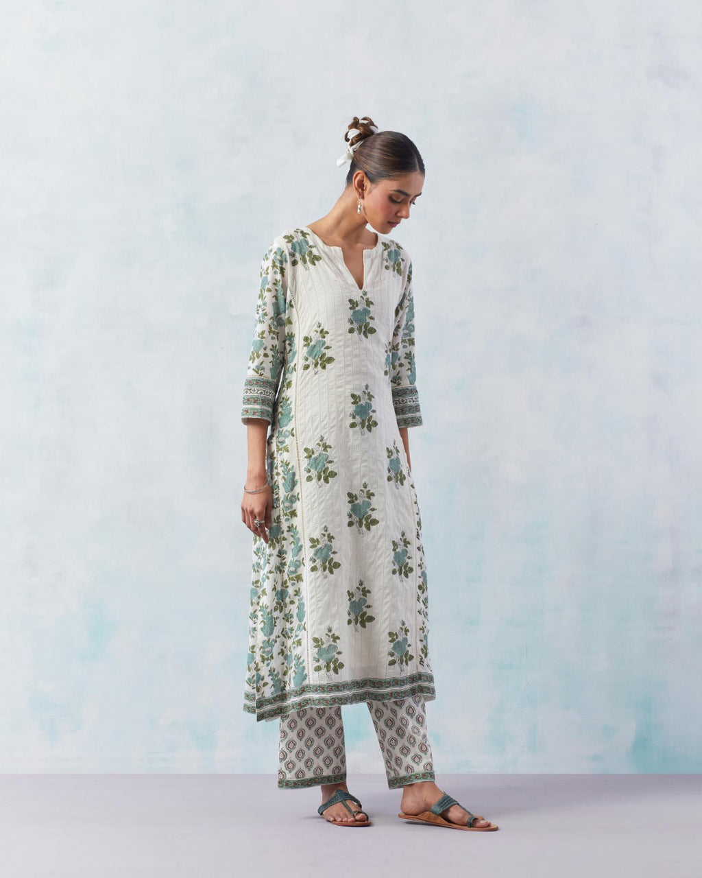 Off white cotton hand block printed straight kurta set with all-over teal green flowers and side panels attached with ladder lace.