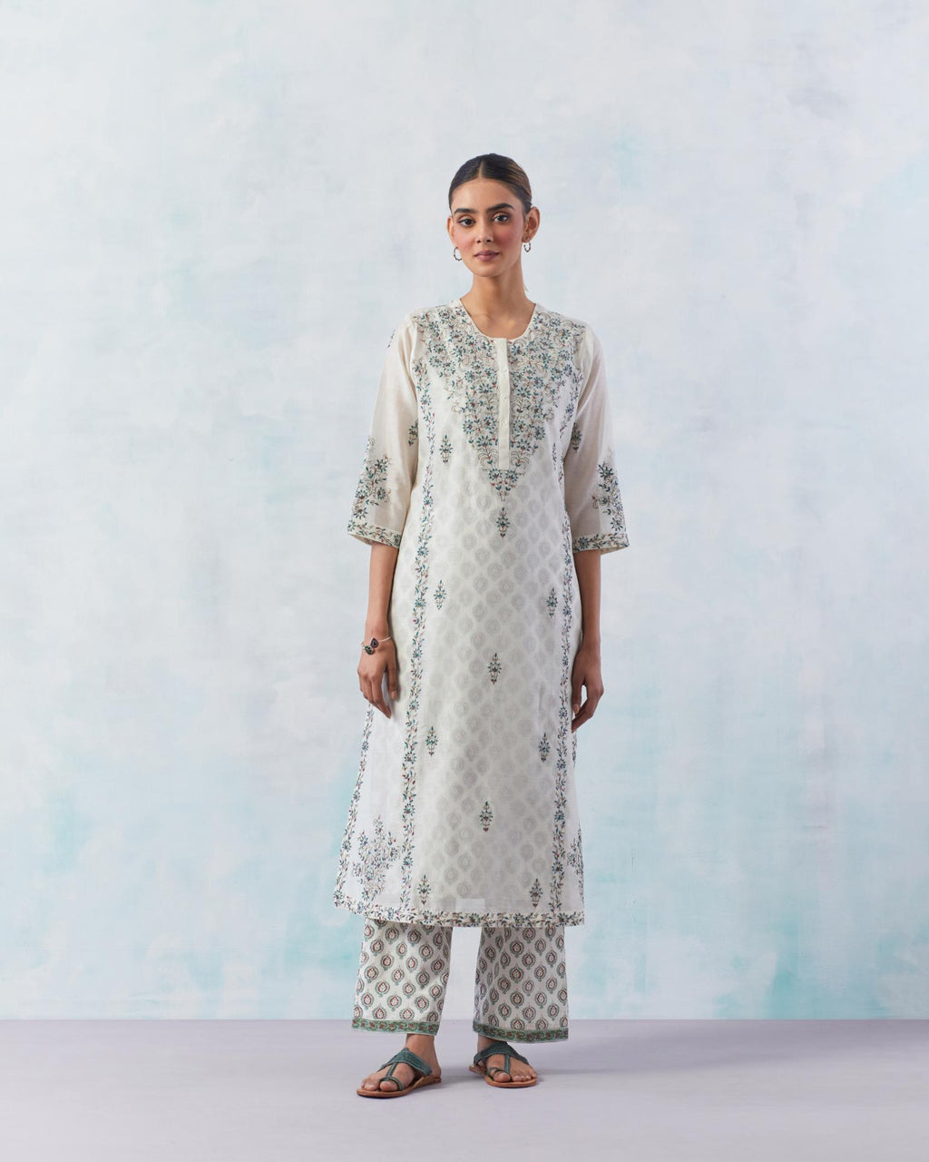Off white kalidar straight kurta set with contrast silk thread embroidery, highlighted with red sequins work.