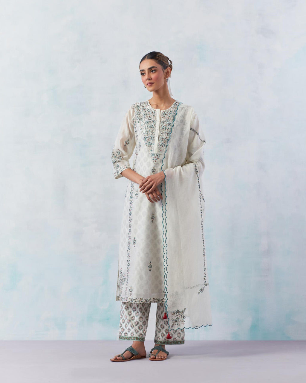 Off white kalidar straight kurta set with contrast silk thread embroidery, highlighted with red sequins work.