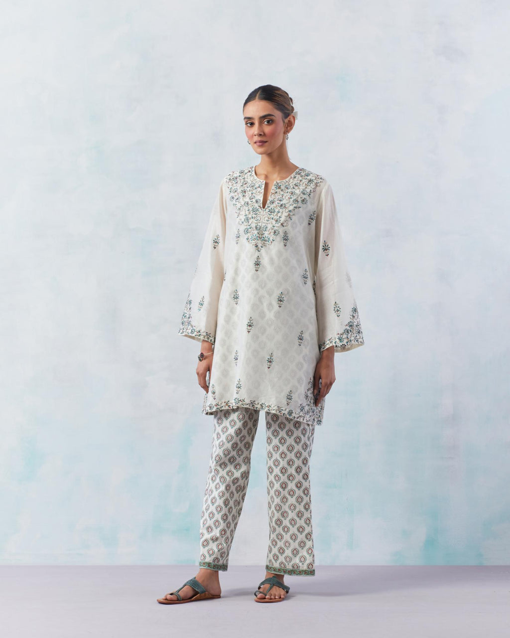 Off white silk chanderi easy fit short kurta, highlighted with contrast silk thread embroidery, highlighted with red sequins.