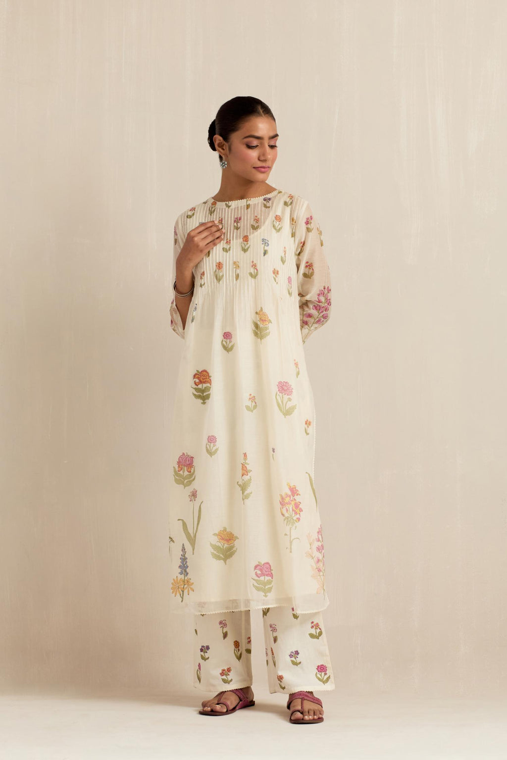 Off white cotton chanderi hand block printed kurta set with pin tucks at yoke and all-over multi colored flower.