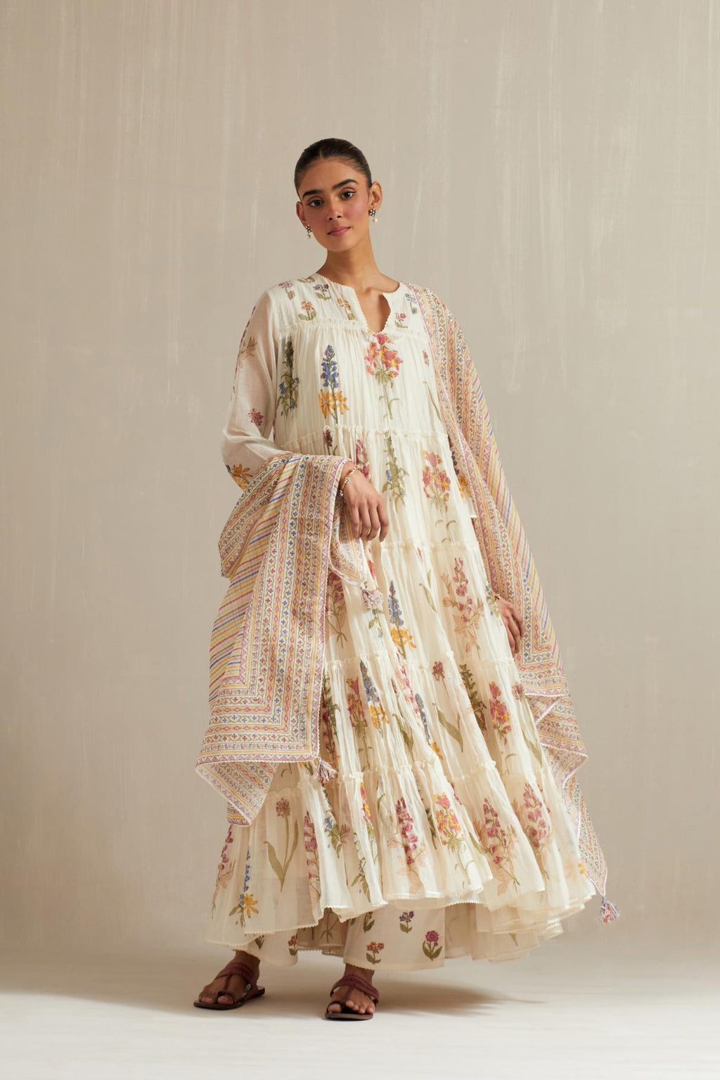 Off white hand block printed multi-tiered kurta set with quilted yoke and all-over multi colored flower.