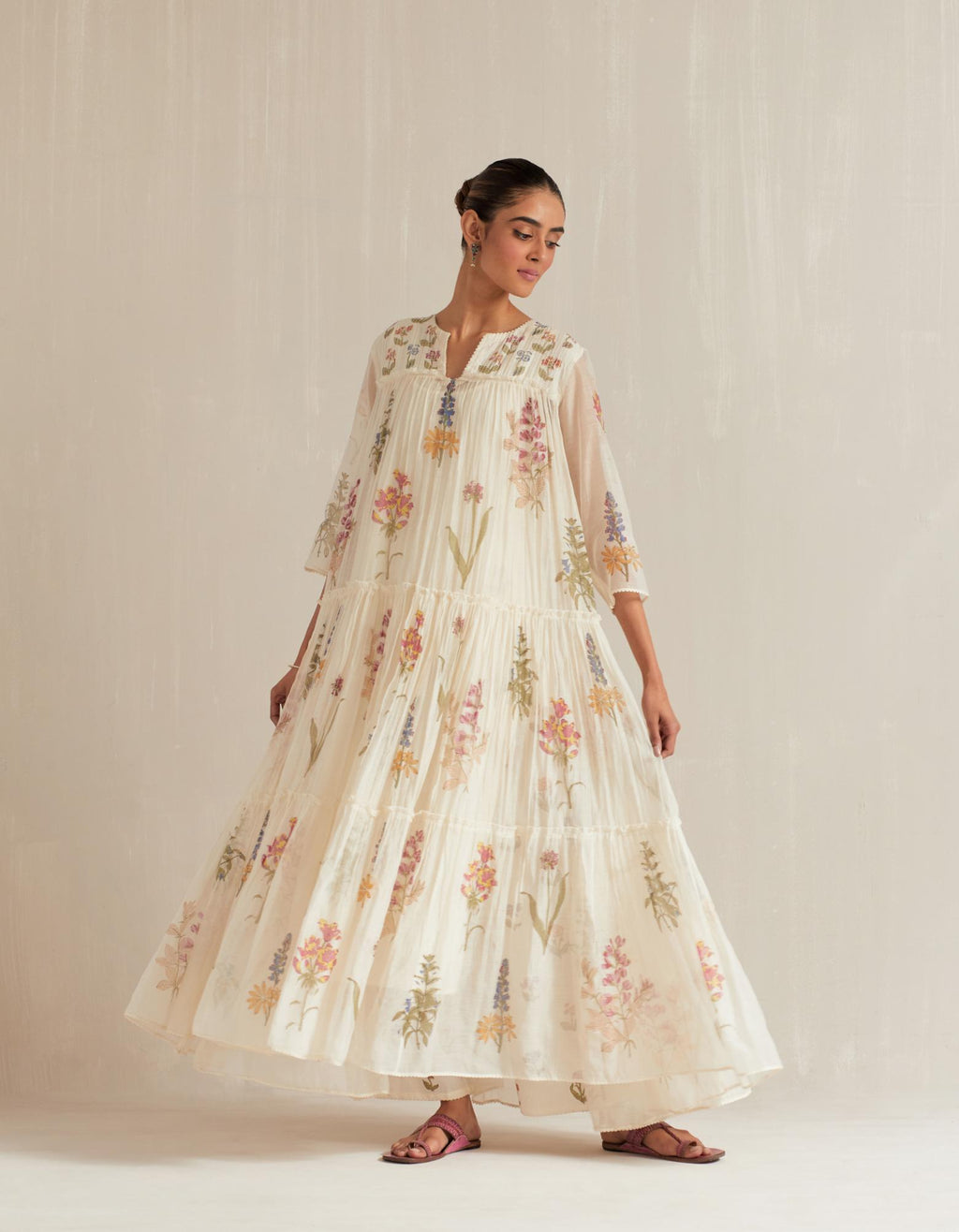 Off white hand block printed three-tiered kurta set with quilted yoke and all-over multi colored flower.