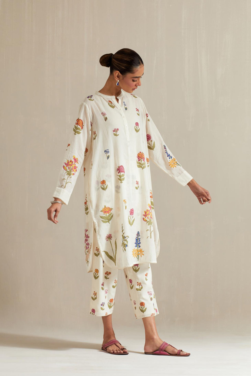 Off white cotton straight short kurta with all-over multi colored flower, paired with off white hand block printed Cotton straight ankle length pants with all-over multi colored flower.