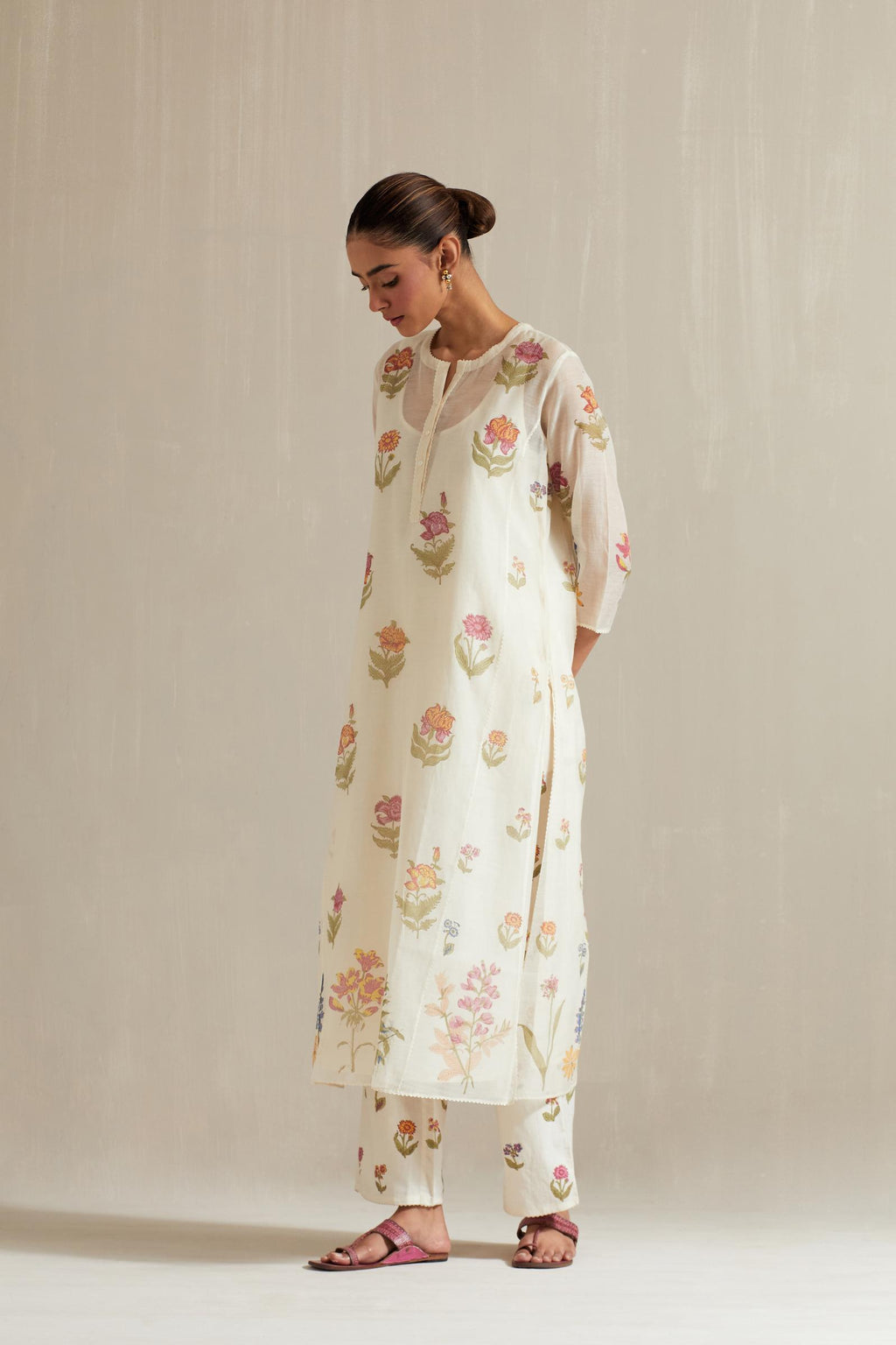 Off white cotton chanderi hand block printed straight kurta set with all-over multi colored flowers and side panels.