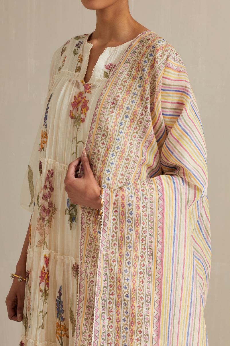 Off white hand block printed multi-tiered kurta set with quilted yoke and all-over multi colored flower.
