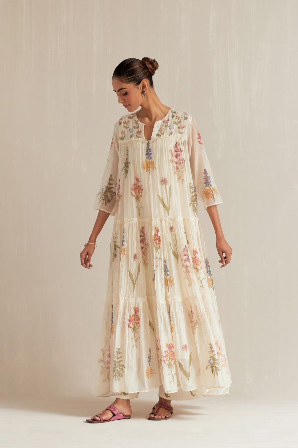 Off white hand block printed three-tiered kurta set with quilted yoke and all-over multi colored flower.
