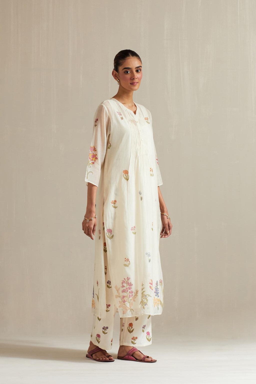 Off white cotton chanderi hand block printed straight kurta set with pin tucks at yoke and all-over multi colored flower.