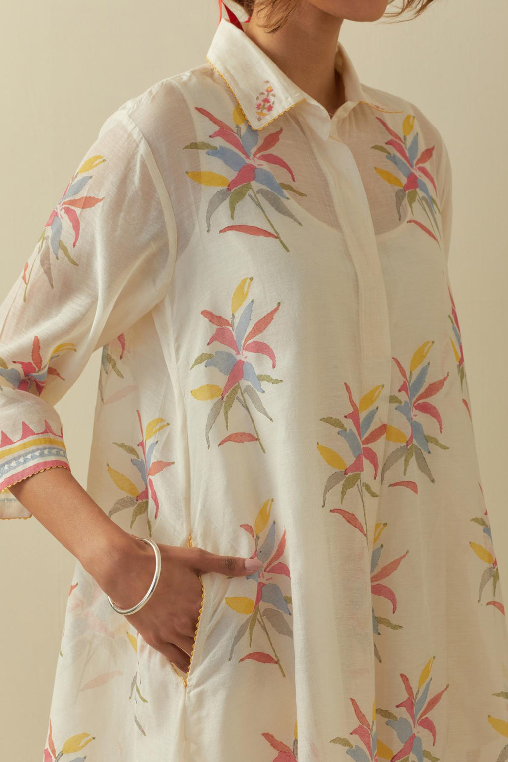 Off white hand block printed A-line short kurta with all-over multi colored flower boota, paired with multi colored striped hand block printed cotton straight pants.