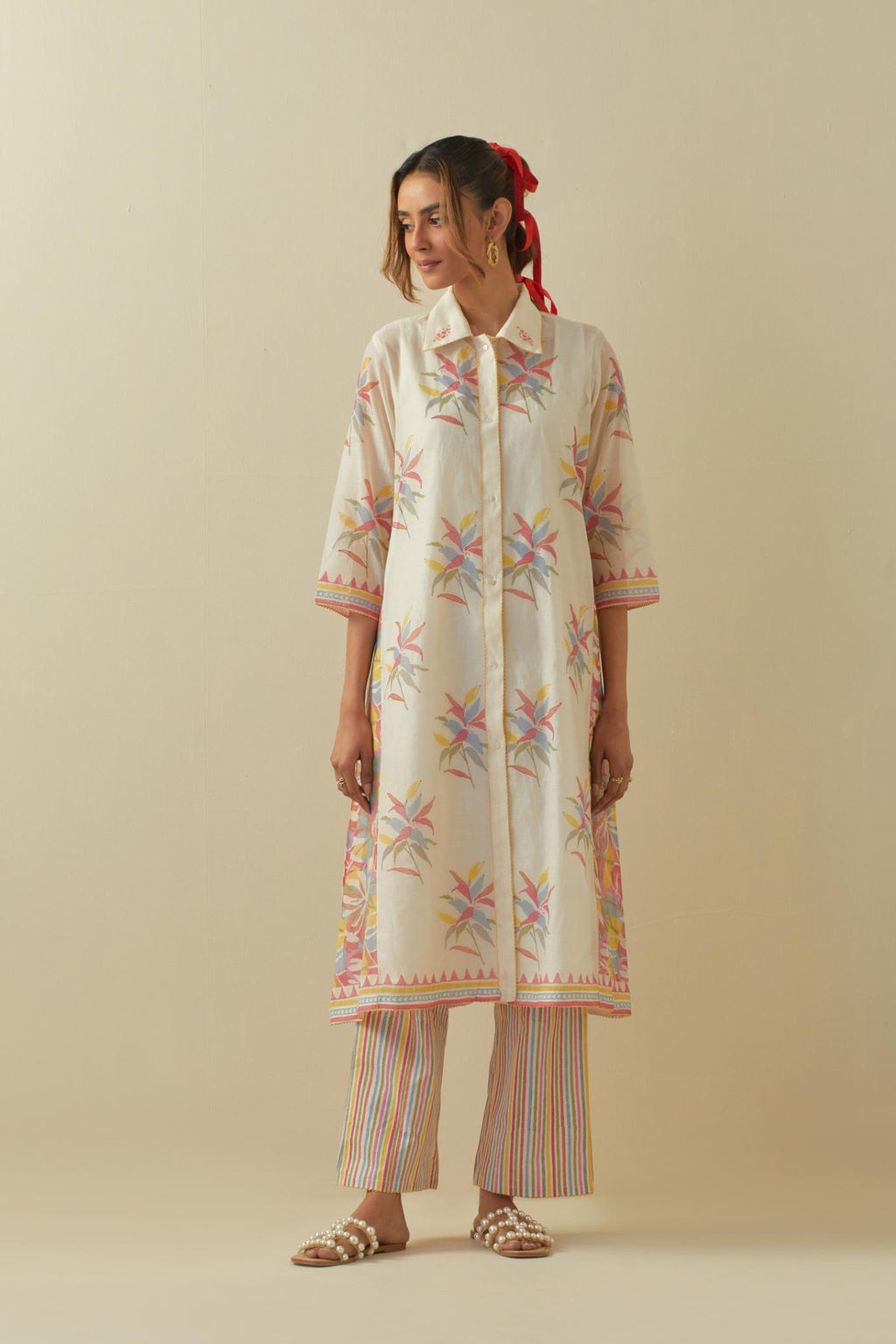 Off white hand block printed A-line short kurta with all-over multi colored hand block printed boota and side panels, paired with multi colored striped hand block printed cotton straight pants.