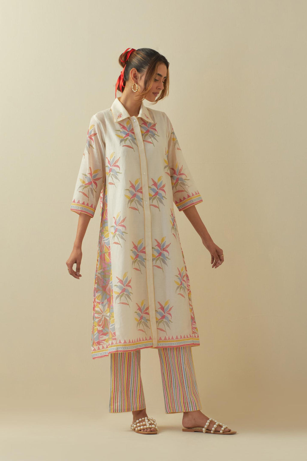 Off white hand block printed A-line short kurta with all-over multi colored hand block printed boota and side panels, paired with multi colored striped hand block printed cotton straight pants.