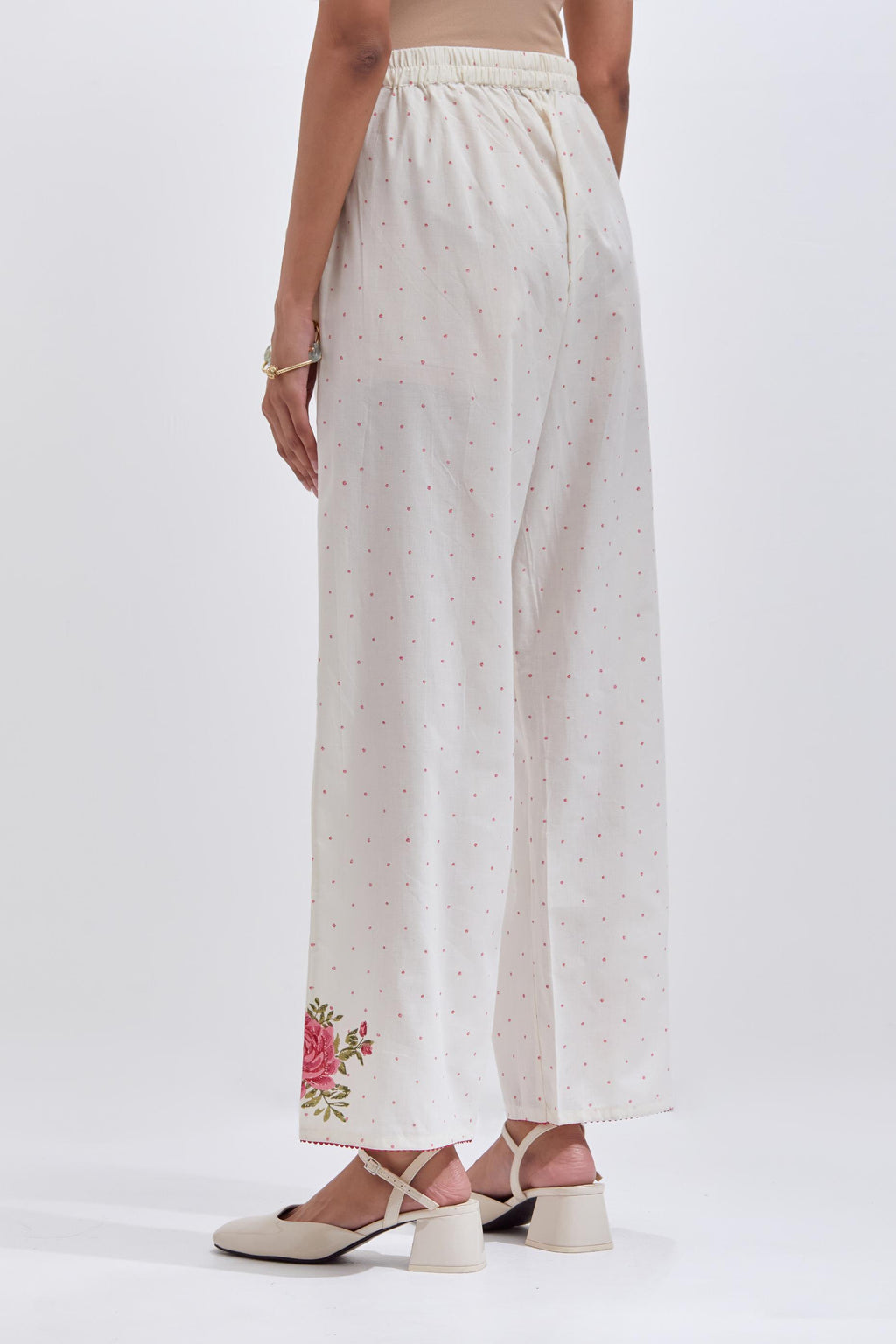 Off white cotton straight pants with all-over pink & green hand block print.