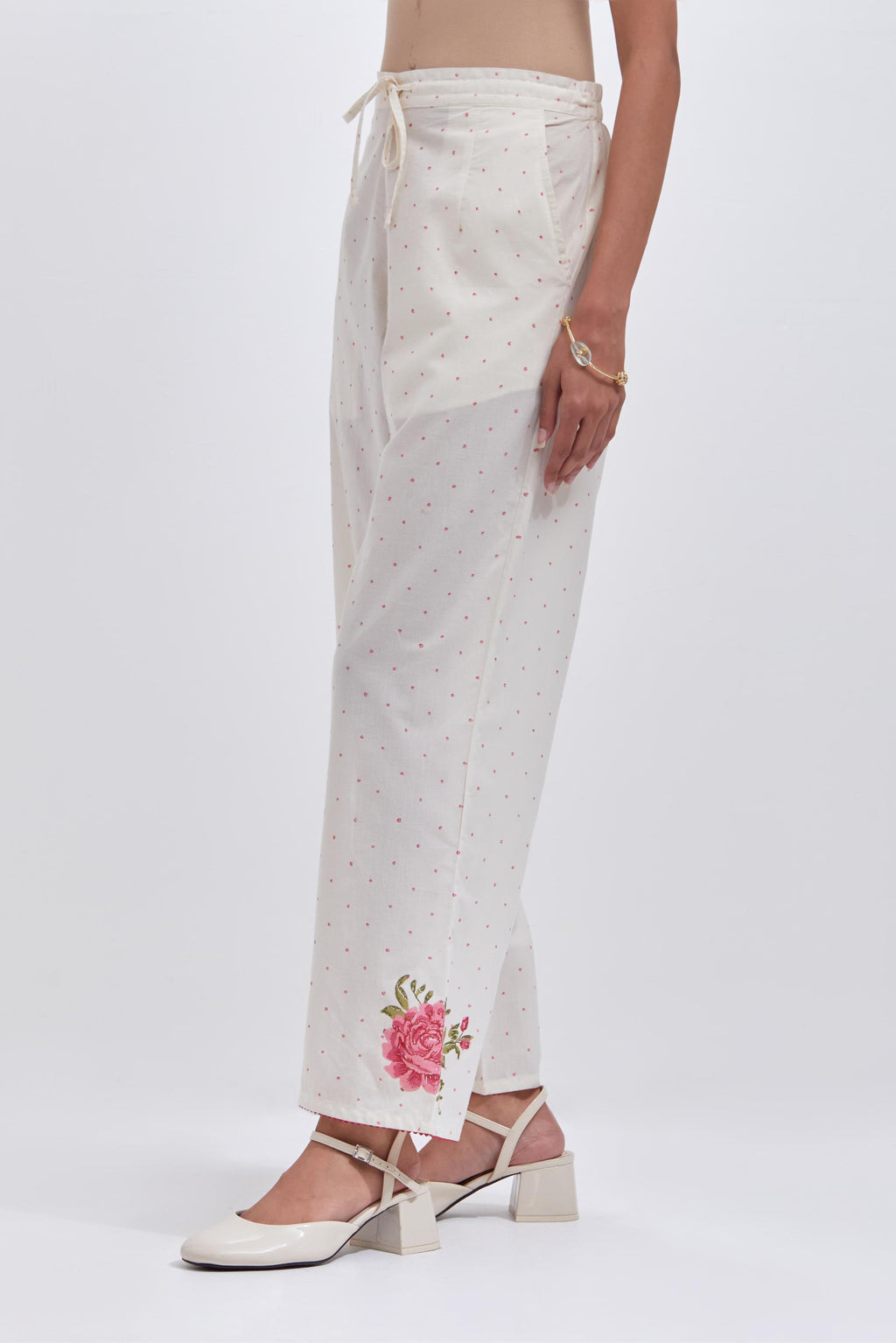 Off white cotton straight pants with all-over pink & green hand block print.