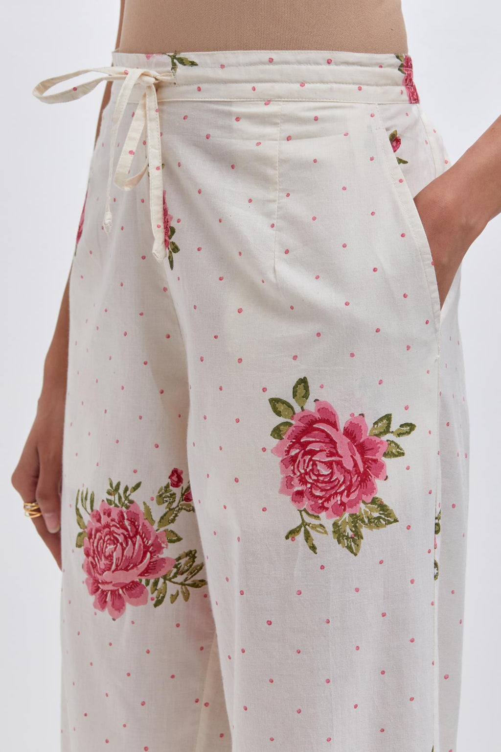Off white cotton straight pants with all-over pink & green floral hand block print.