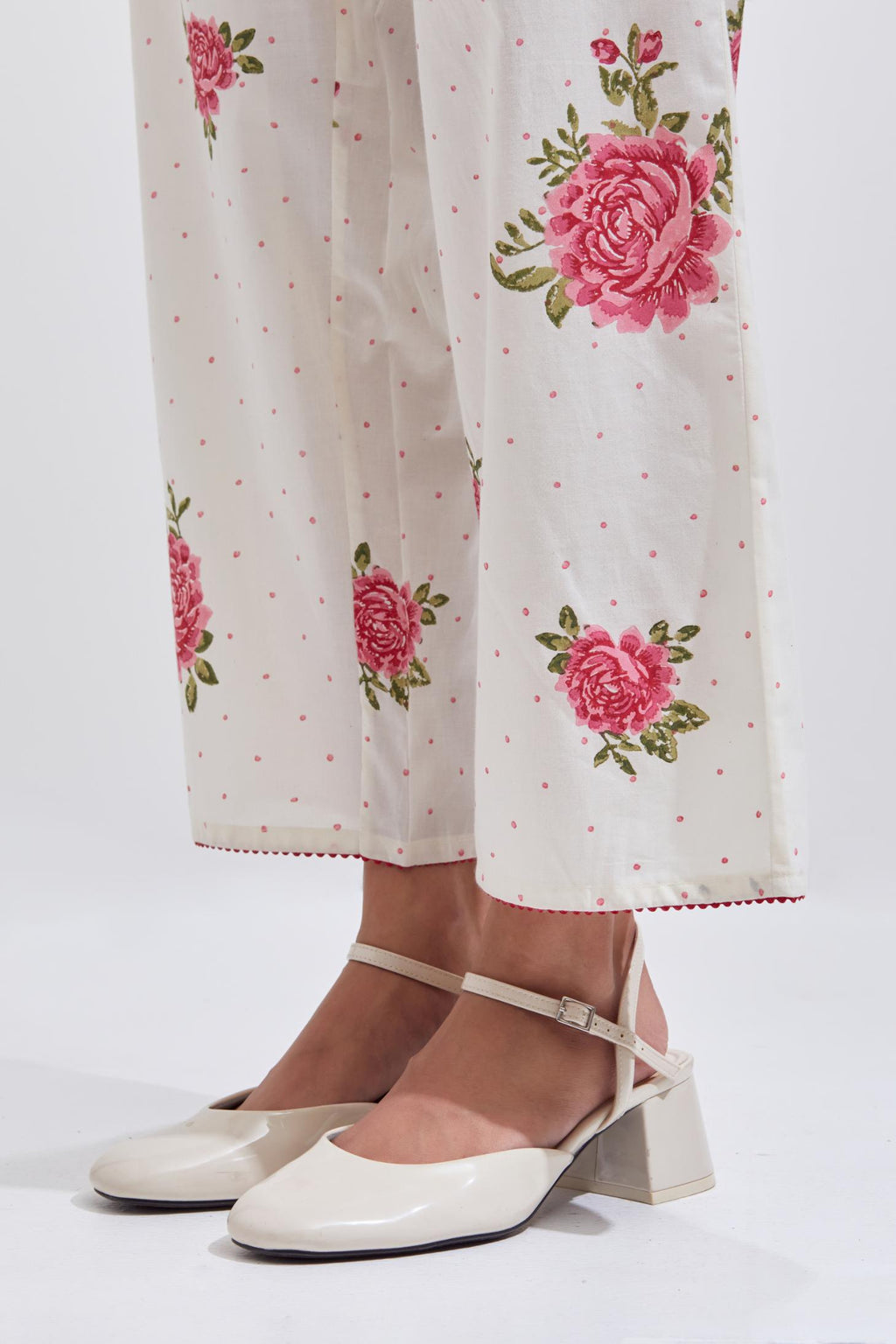 Off white cotton straight pants with all-over pink & green floral hand block print.