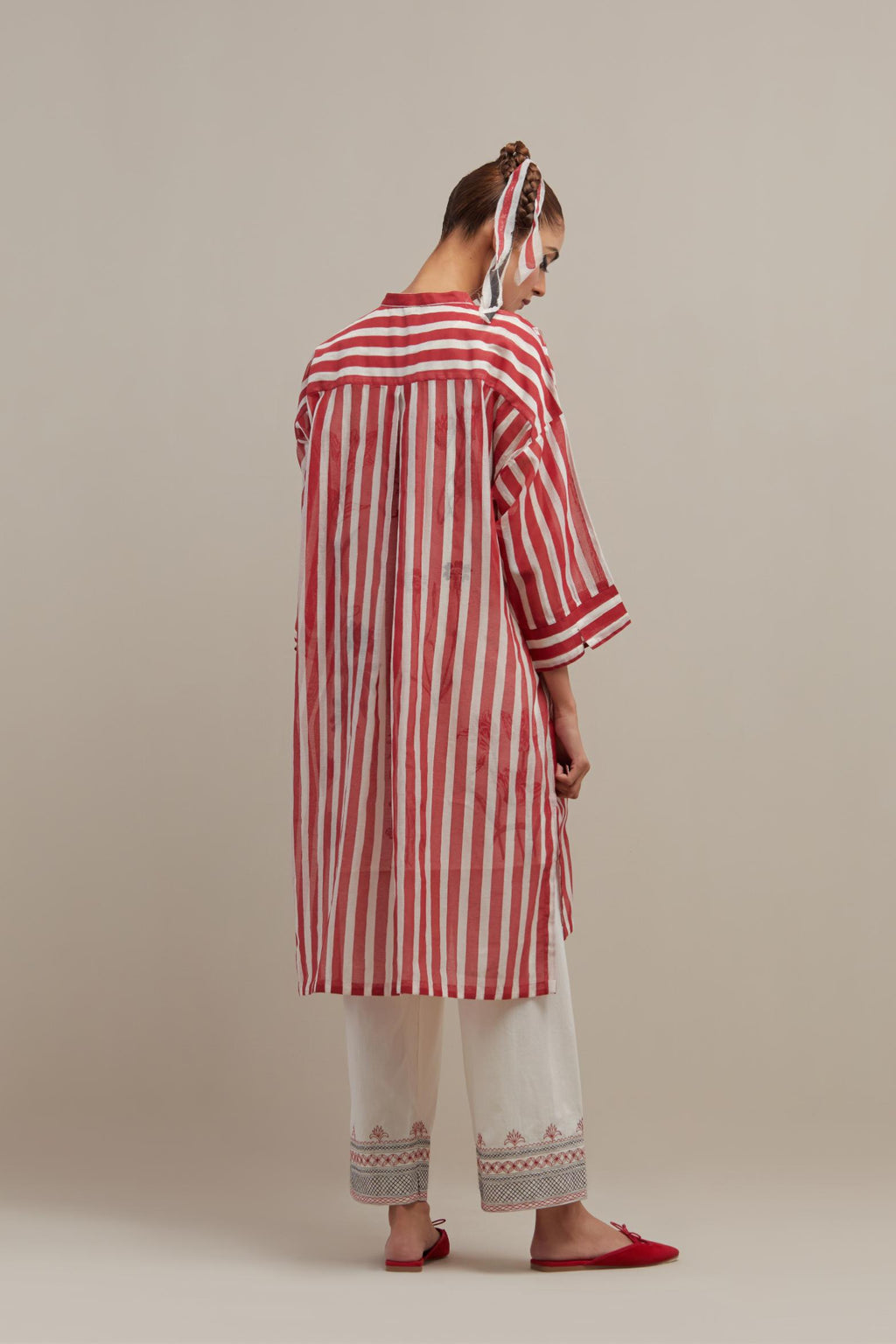 Red & off-white cotton chanderi hand block printed easy fit kurta with band collar neckline, paired with off white straight pants with quilted embroidery at bottom hem.