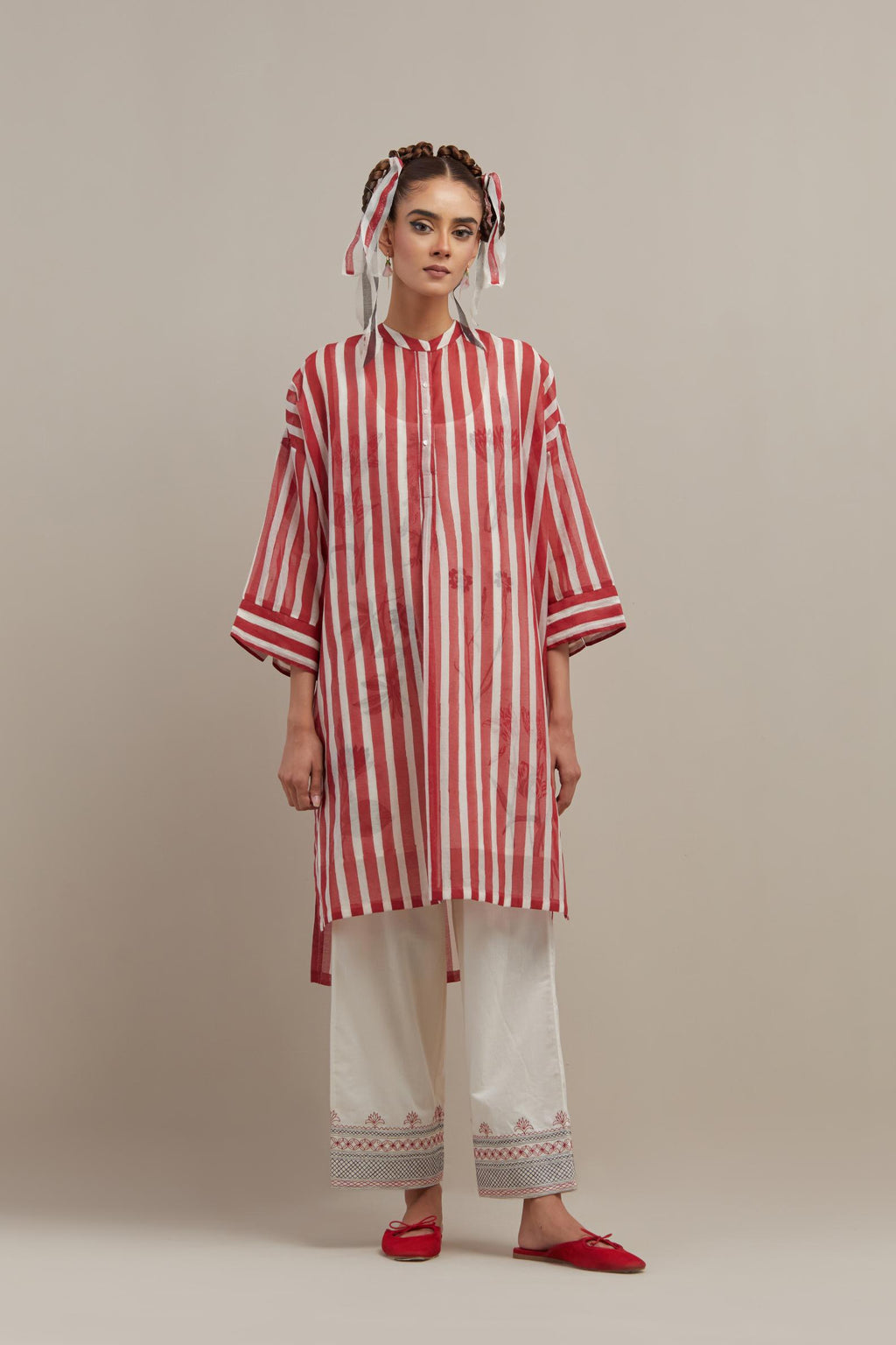 Red & off-white cotton chanderi hand block printed easy fit kurta with band collar neckline, paired with off white straight pants with quilted embroidery at bottom hem.