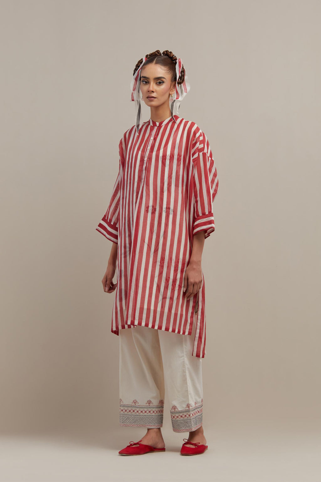 Red & off-white cotton chanderi hand block printed easy fit kurta with band collar neckline, paired with off white straight pants with quilted embroidery at bottom hem.