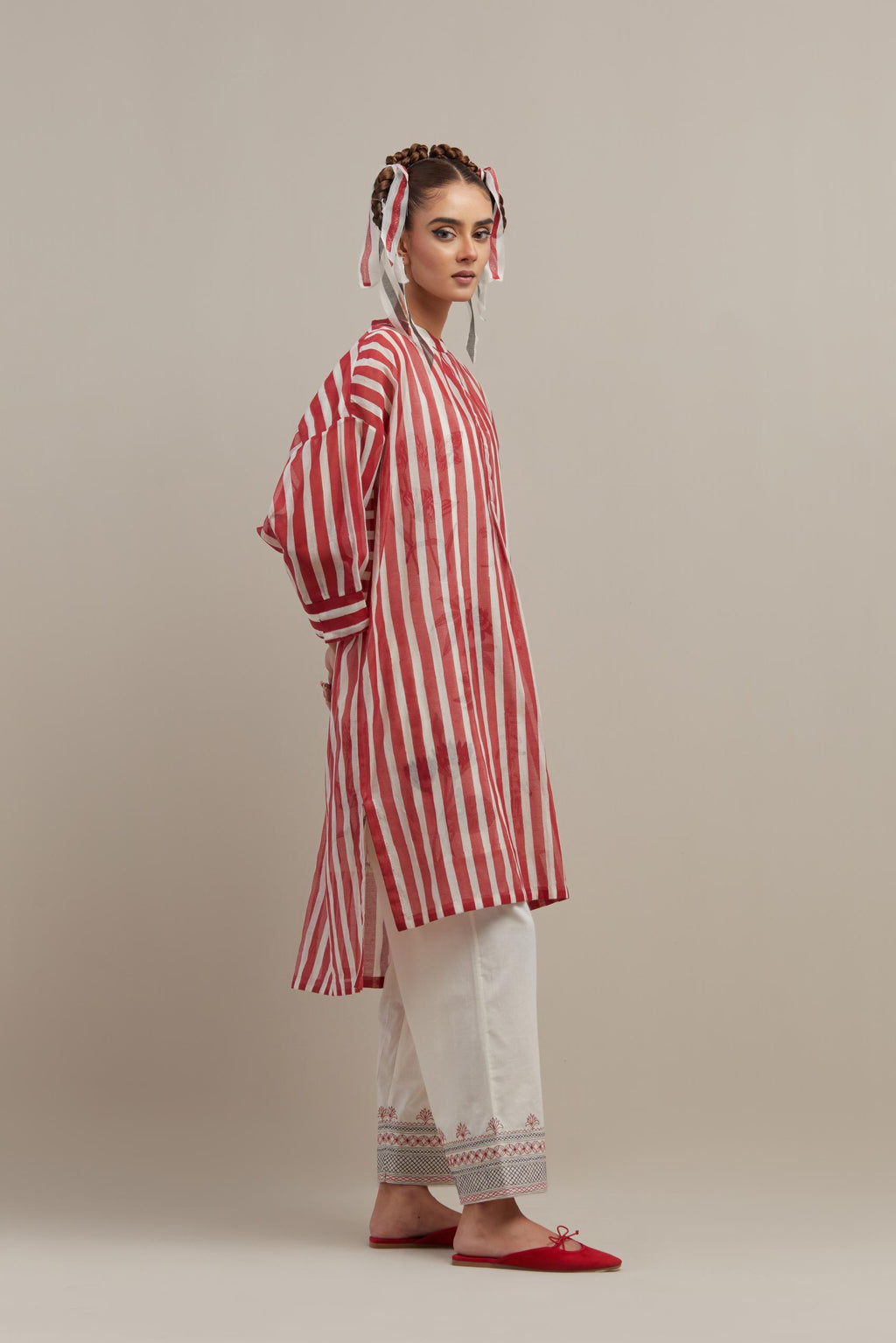 Red & off-white cotton chanderi hand block printed easy fit kurta with band collar neckline, paired with off white straight pants with quilted embroidery at bottom hem.