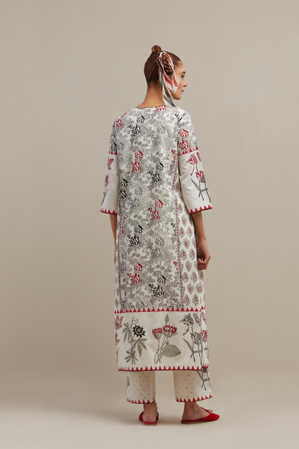 Off white cotton hand block printed straight kurta set with red & black colored flower and border detail at hem.