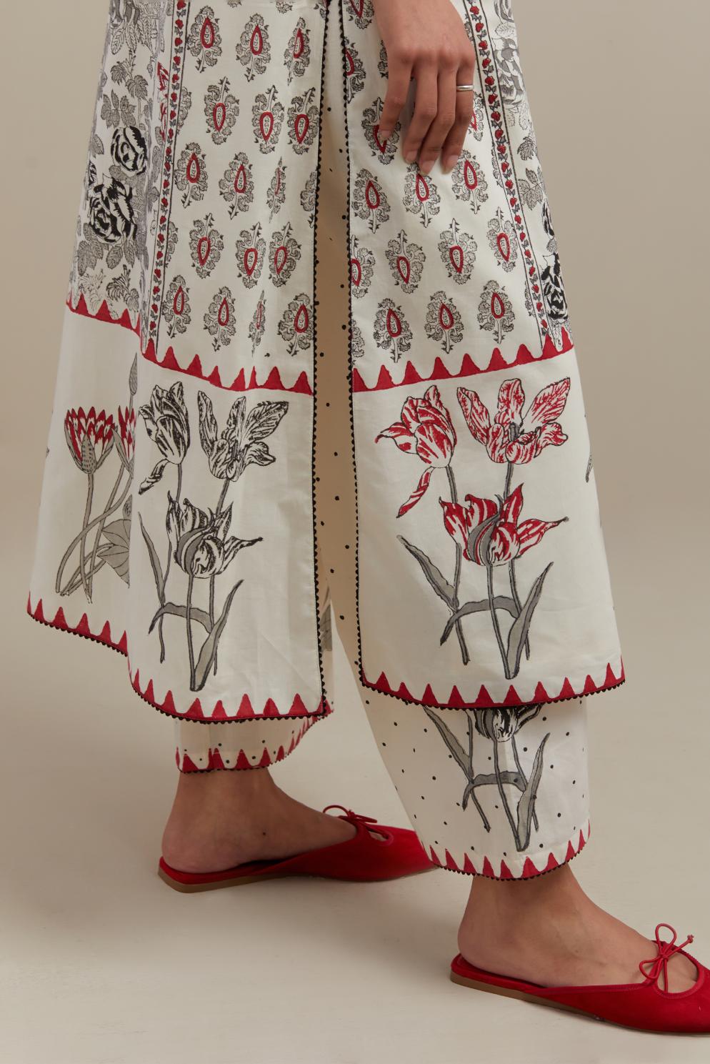 Off white cotton hand block printed straight kurta set with red & black colored flower and border detail at hem.