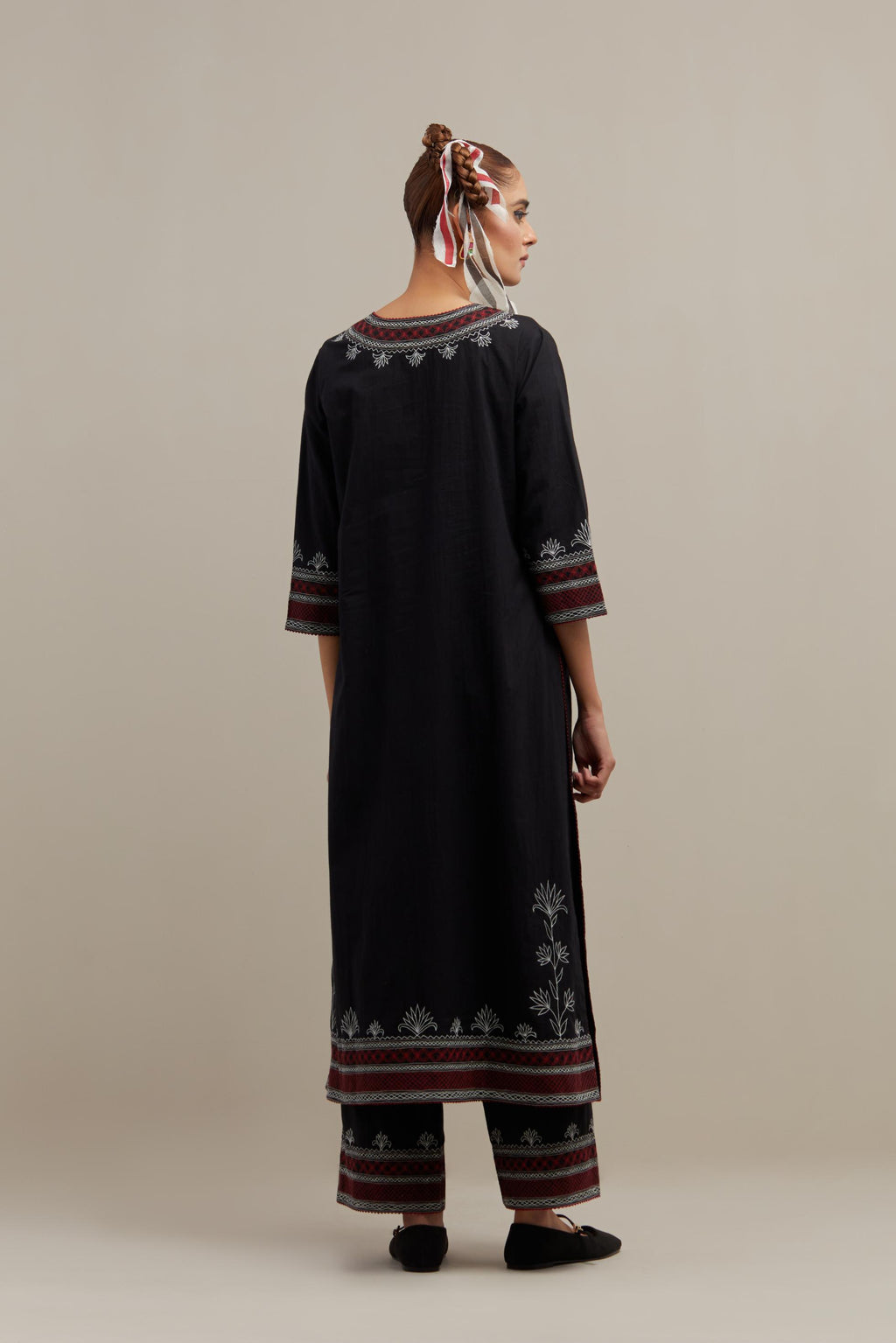 Black cotton straight kurta set with Red & off-white embroidery at neck, hem and sleeves.