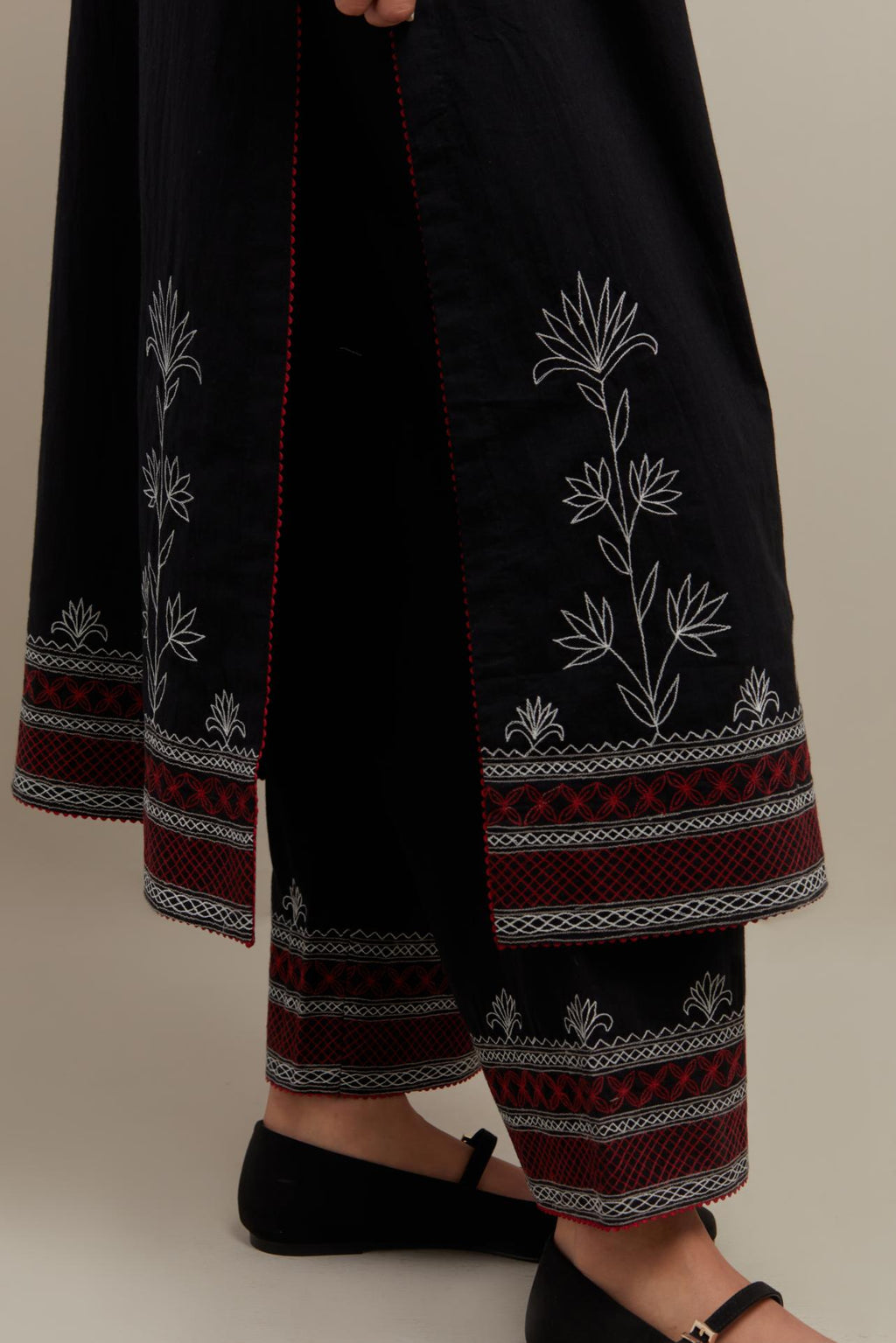 Black cotton straight kurta set with Red & off-white embroidery at neck, hem and sleeves.