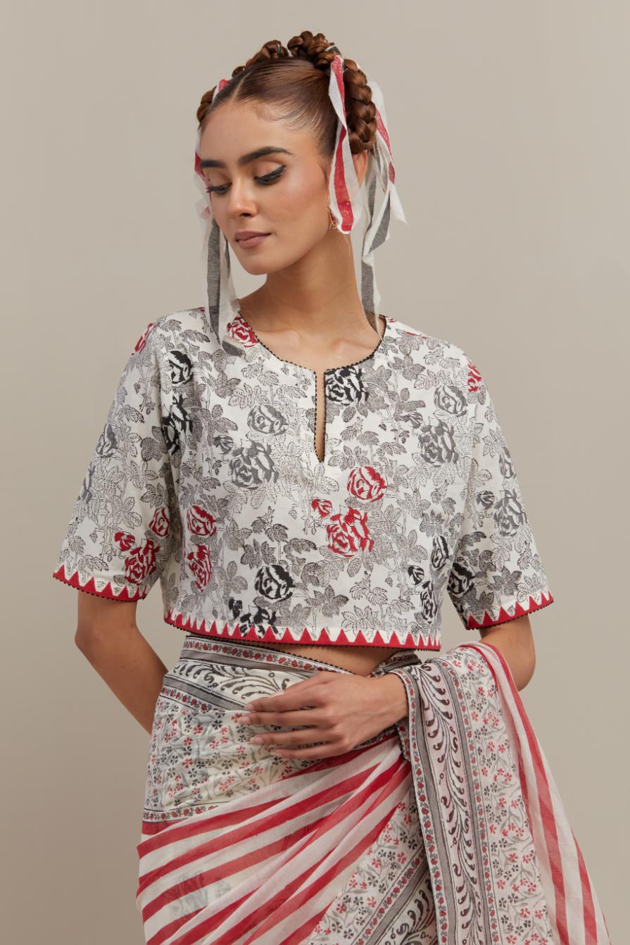 Off white cotton chanderi saree, highlighted with all-over bold stripe and floral hand block print, paired with off-white hand block printed cotton blouse, paired with off-white cotton blouse with all-over red & black hand block print.