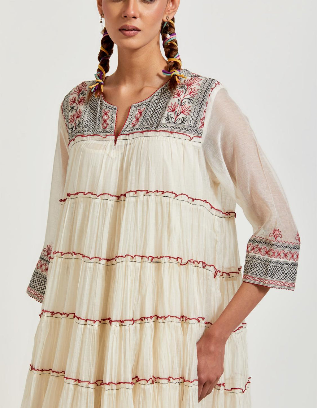 Off white cotton chanderi multi-tiered kurta dress set with 3/4 sleeves, highlighted with red & black quilted embroidered yoke in front and back.