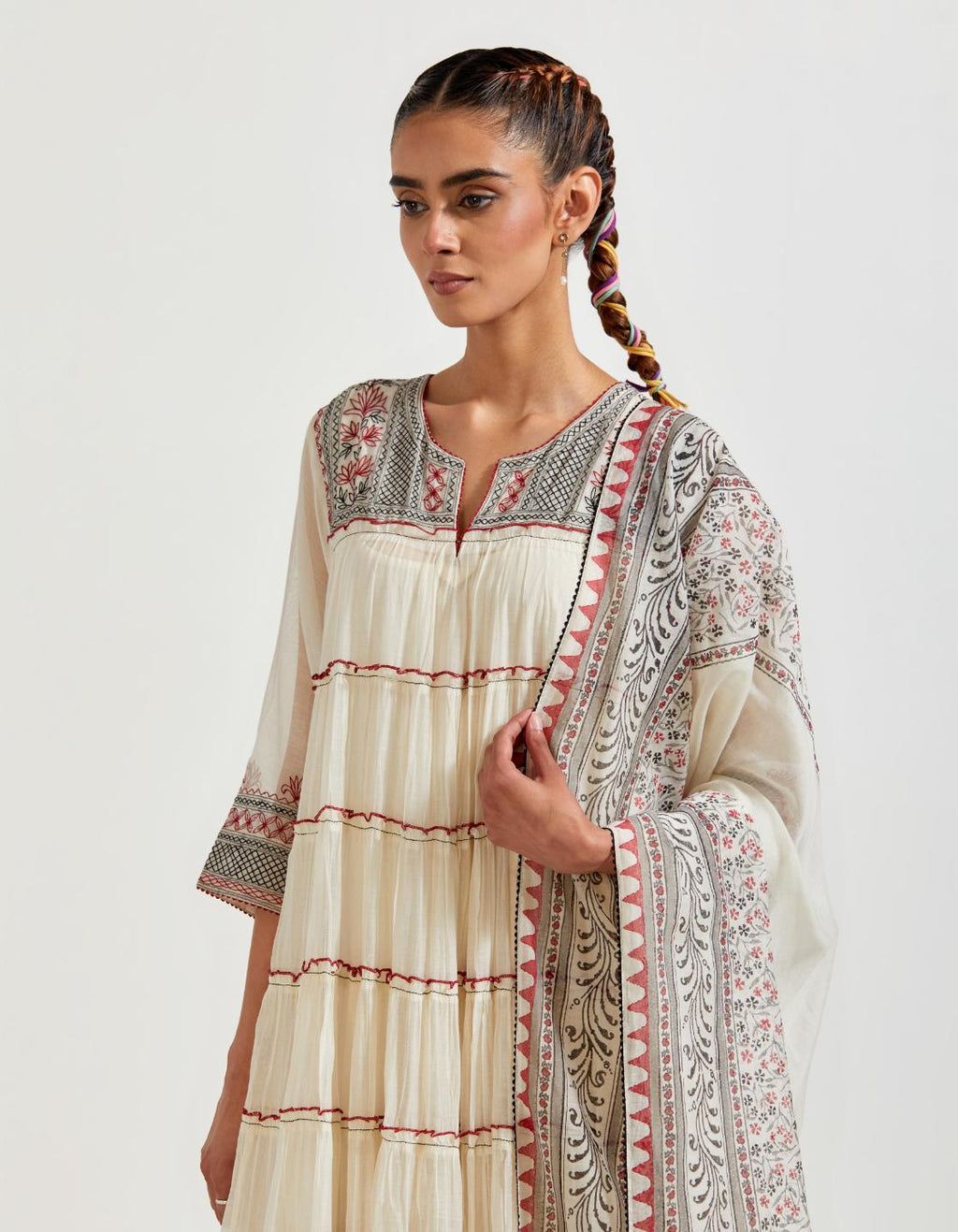 Off white cotton chanderi multi-tiered kurta dress set with 3/4 sleeves, highlighted with red & black quilted embroidered yoke in front and back.